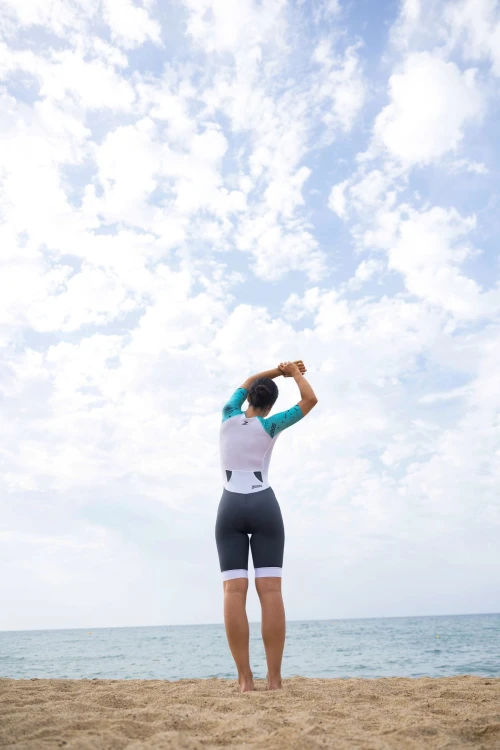 Strój-triathlonowy-turkusowo-biały-kobieta-stojąca-tyłem-na-plaży.jpg