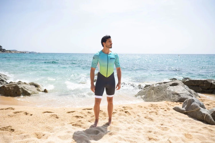 Strój-triathlonowy-turkusowo-biały-mężczyzna-stojący-na-plaży-przodem.jpg