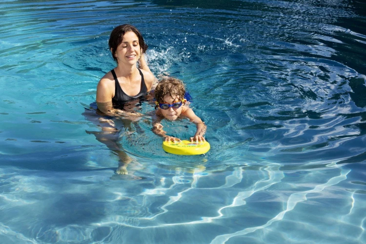 Dzieco-płynie-z-deską-asekurowane-przez-mamę.jpg